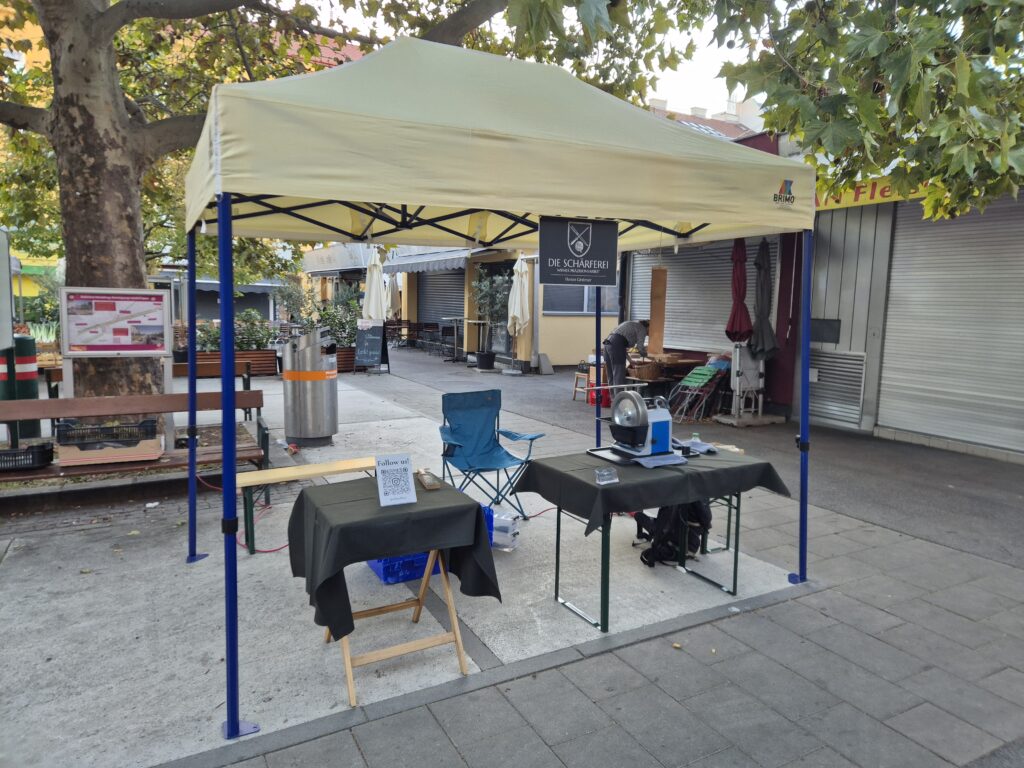 Marktstand der Schärferei mit Tisch und Tormek auf dem Meidlinger Markt in Wien